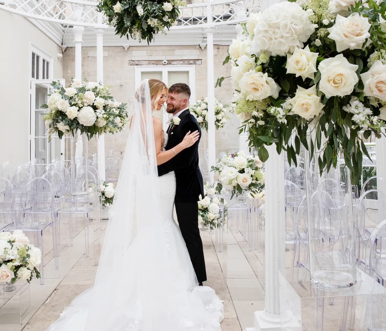 Bride and groom in a bright floral ceremony space